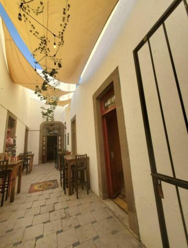 a room with tables and chairs and a building at Casa Tatewari in San Luis Potosí