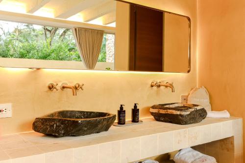 a bathroom with a large stone sink and a mirror at Arde La Selva in Santa Fe de Antioquia