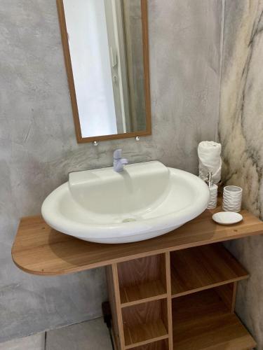 a bathroom sink with a mirror on a wooden table at Studio Bia in Natal