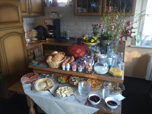 stół z wieloma różnymi rodzajami żywności w obiekcie Pension Am Klünderberg w mieście Binz