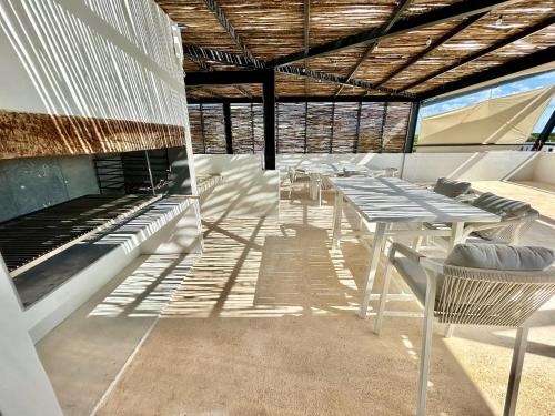a patio with tables and chairs and a fireplace at ZEL-VA Tulum Apartments in Tulum