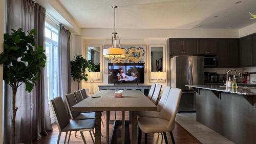 a kitchen with a table and chairs and a refrigerator at 9 Queen Beds, 18 Guests-Kleinburg Luxe Crown Town Residence in Vaughan