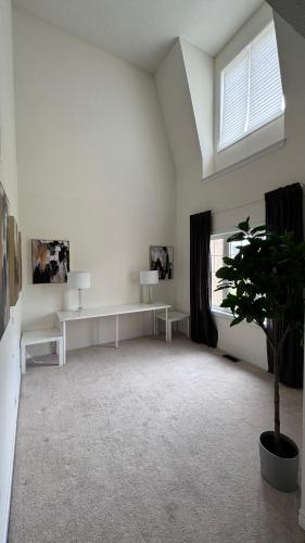 a white room with a table and a plant at 9 Queen Beds, 18 Guests-Kleinburg Luxe Crown Town Residence in Vaughan