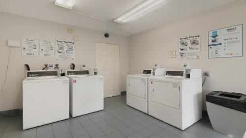 a room with four washing machines in a room at Howard Johnson by Wyndham Sacramento Downtown in Sacramento