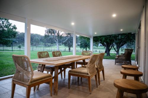 a patio with a wooden table and chairs at Wisteria Cottage Rylstone in Rylstone