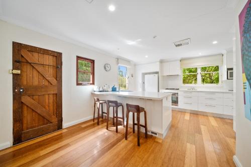 a kitchen with white cabinets and a wooden door at Comfortable 3-Bed Haven Near Canberra Attractions in Narrabundah