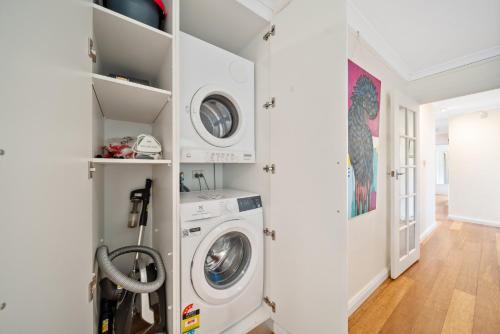 a white laundry room with a washer and dryer at Comfortable 3-Bed Haven Near Canberra Attractions in Narrabundah