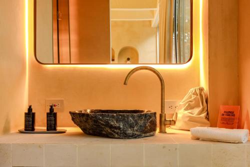 a bathroom counter with a sink with a stone sink at Arde La Selva in Santa Fe de Antioquia