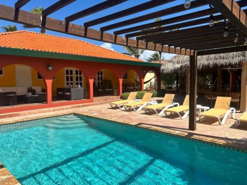 une piscine avec des chaises longues et une maison dans l'établissement Casa Opal, à Palm-Eagle Beach
