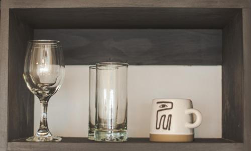 a shelf with two glasses and a clock and a wine glass at Loft By Toore Patagonia in Puerto Natales