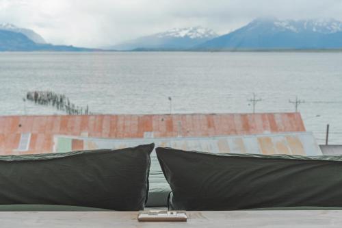 two pillows sitting on a table next to a body of water at Loft By Toore Patagonia in Puerto Natales