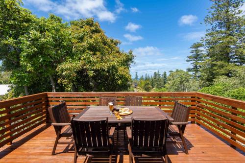 a wooden deck with a table and chairs on it at Bucks Point - Norfolk Island Holiday Homes in Burnt Pine