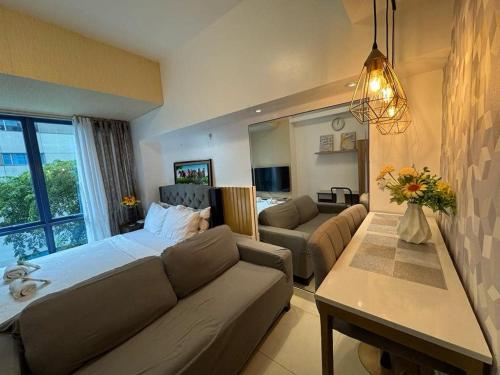 una sala de estar con una cama y un sofá en ARC Studio Unit at 38th Park, en Cebú