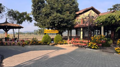 a building with benches and flowers in front of it at Jungle Wildlife Camp in Sauraha