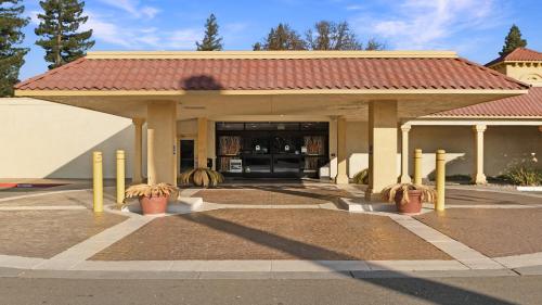 a building with a red roof with potted plants at Howard Johnson by Wyndham Sacramento Downtown in Sacramento