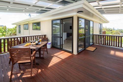 a deck with a table and chairs on it at Bucks Point - Norfolk Island Holiday Homes in Burnt Pine