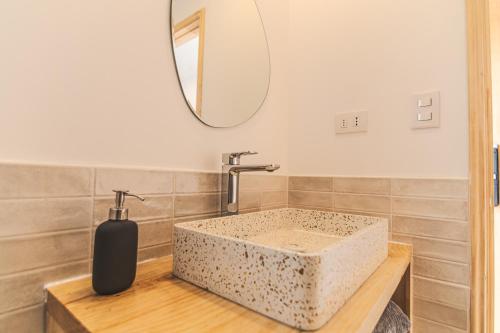 a bathroom with a stone sink and a mirror at Loft By Toore Patagonia in Puerto Natales
