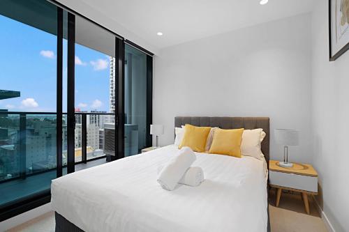 a bedroom with a large white bed with a large window at Lumina Stays - Lighthouse in Melbourne
