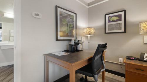 a hotel room with a desk and a chair at Howard Johnson by Wyndham Sacramento Downtown in Sacramento