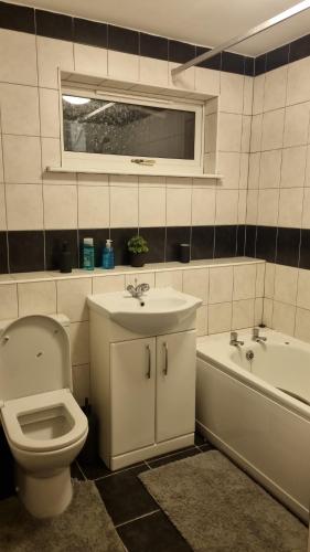 a bathroom with a toilet and a sink and a tub at Apple valley in Manchester