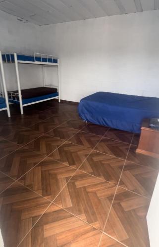 a room with a bed and a wooden floor at Mogi 2 in Mogi das Cruzes