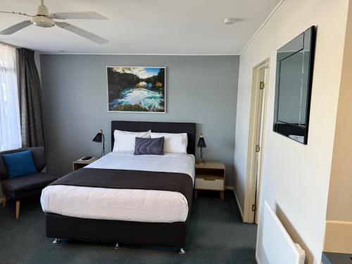 a hotel room with a bed and a tv at Academy Motor Inn in Tauranga