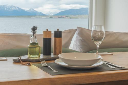 a table with a plate and a glass of wine at Loft By Toore Patagonia in Puerto Natales