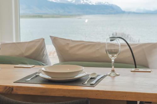 a table with a plate and a glass on it at Loft By Toore Patagonia in Puerto Natales
