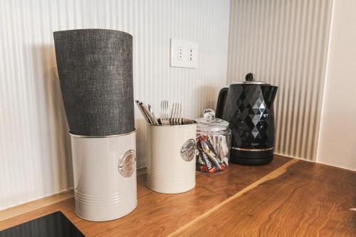 two white trash cans sitting on a wooden table at Loft By Toore Patagonia in Puerto Natales