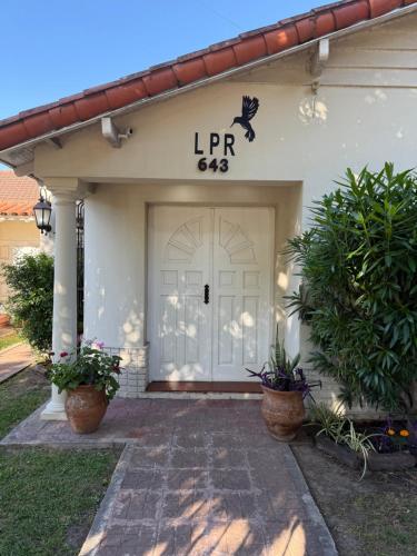 a front door of a house with a sign that reads lr at LPR Express EZE Airport in Monte Grande