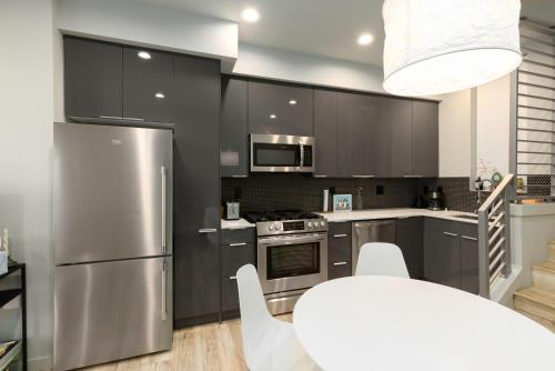 a kitchen with stainless steel appliances and a table at West Seattle - Mins to Downtown! in Seattle