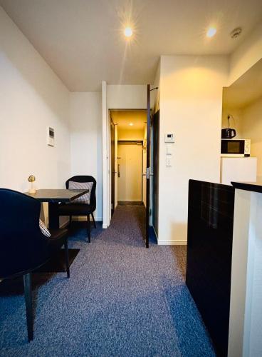 a room with a table and chairs and a hallway at 嵐 Arashi BNB 日本橋 No8111 in Osaka