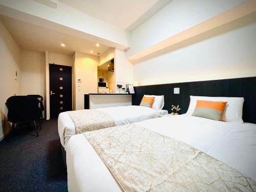 a hotel room with two beds and a desk at 嵐 Arashi BNB 日本橋 No8111 in Osaka