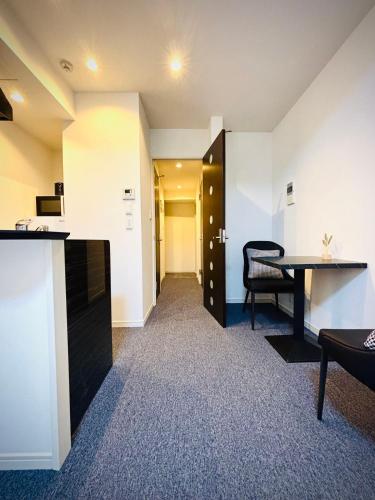 a room with a desk and a table and a hallway at 嵐 Arashi BNB 日本橋 No8111 in Osaka
