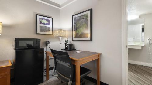 a room with a desk with a chair and a television at Howard Johnson by Wyndham Sacramento Downtown in Sacramento