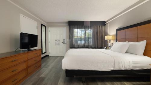 a bedroom with a large bed and a flat screen tv at Howard Johnson by Wyndham Sacramento Downtown in Sacramento