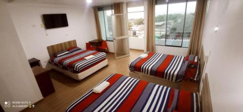 a hotel room with two beds and a balcony at Camber Inn in Máncora