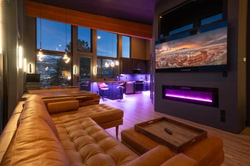 ein Wohnzimmer mit einem großen Sofa und einem Kamin in der Unterkunft Modern Mtn-View Retreat, 18 Mi to Zion North in Cedar City