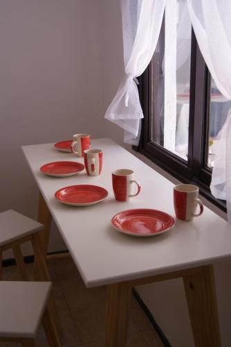 una mesa con platos rojos y tazas. en House Mendoza - Apartamento de 2 plantas, en Mendoza