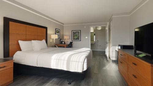 a bedroom with a large bed and a flat screen tv at Howard Johnson by Wyndham Sacramento Downtown in Sacramento