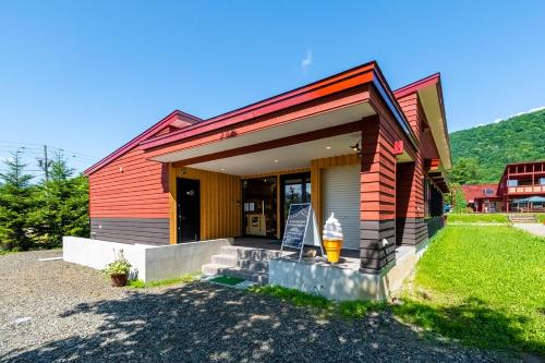 a small red house with a porch and a door at MolinHotels102-アクティビティを満喫できる札幌定山渓 天然温泉付 - W-beds2&S-beds3 in Jozankei