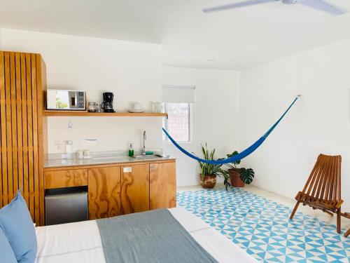 a bedroom with a bed and a sink and a kitchen at Studios Downtown Cancun in Cancún