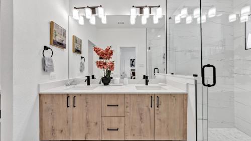 a white bathroom with a sink and a shower at Sophisticated Dallas Retreat l Prime Location! in Dallas