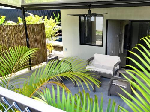 a patio with a white chair and plants at Private Tail House centre Uvita in Uvita