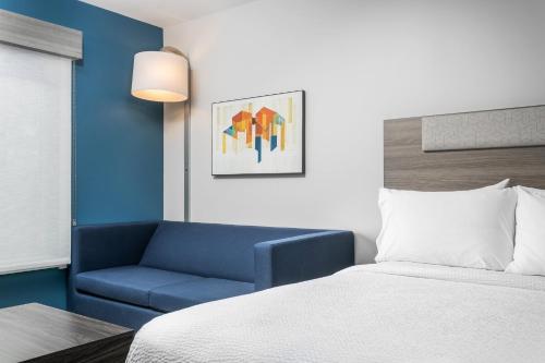a hotel room with a bed and a blue chair at Holiday Inn Express Chattanooga - Hamilton Place in Chattanooga
