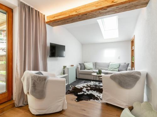 a living room with two white chairs and a couch at Jaggi in Hopfgarten im Brixental