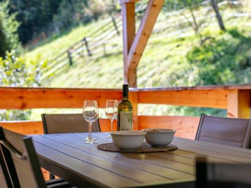a wooden table with a bottle of wine and two glasses at Jaggi in Hopfgarten im Brixental