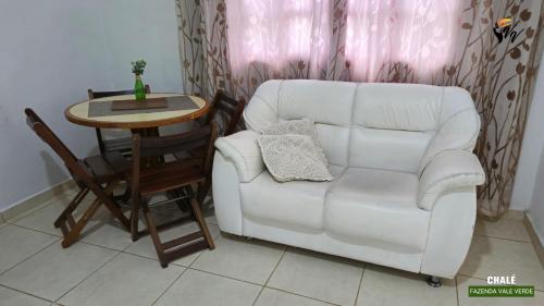 a living room with a white couch and a table at Pousada Fazenda Vale Verde in Sete Barras