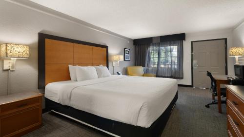 a hotel room with a large bed and a desk at Howard Johnson by Wyndham Sacramento Downtown in Sacramento