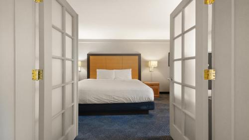 a hotel room with a bed and two doors at Howard Johnson by Wyndham Sacramento Downtown in Sacramento